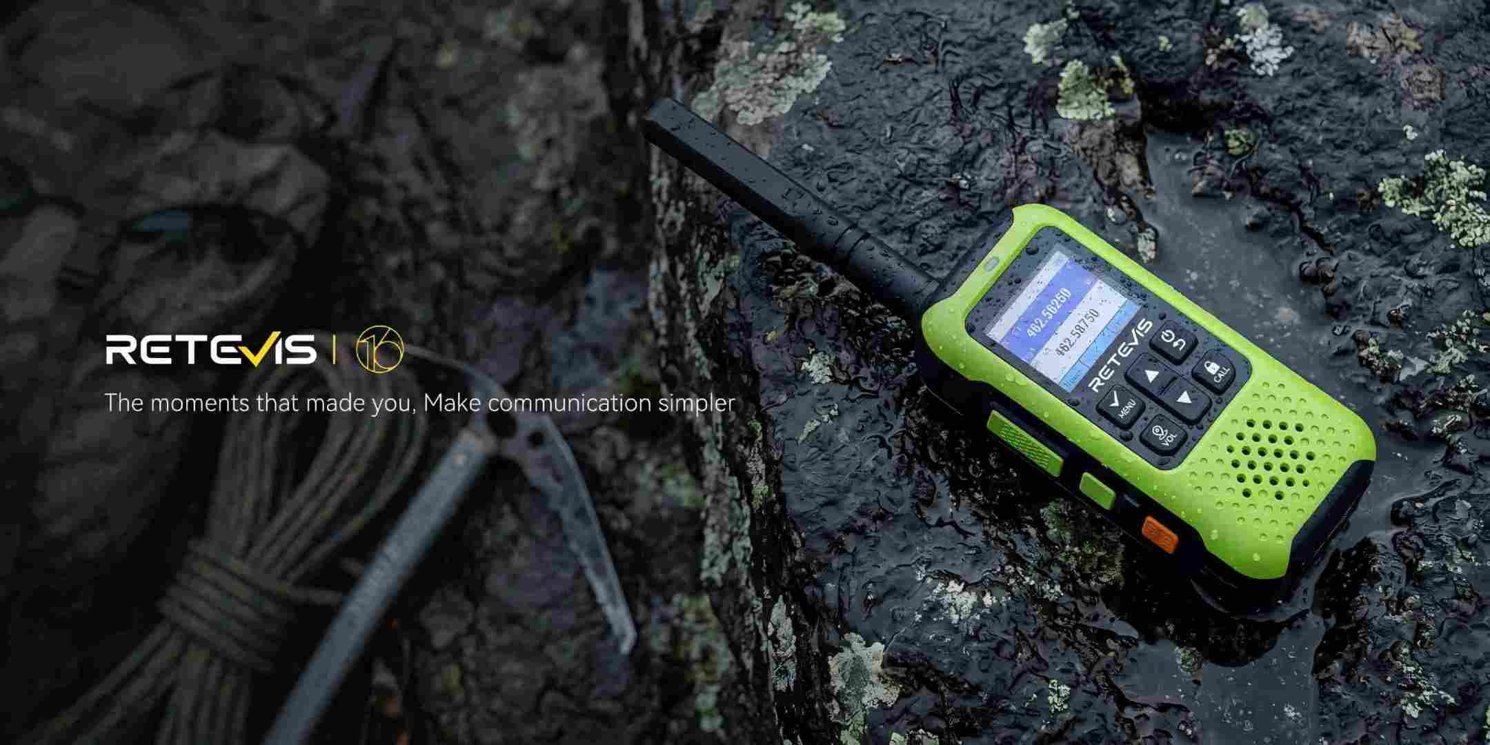 Retevis EZTalk 5 GMRS radio on wet mossy rock with rope and ice axe, showing rugged waterproof durability for outdoor adventures.